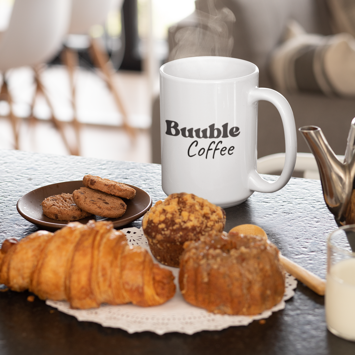 White mug with 'Buuble Coffee' text on a table with pastries and cookies.