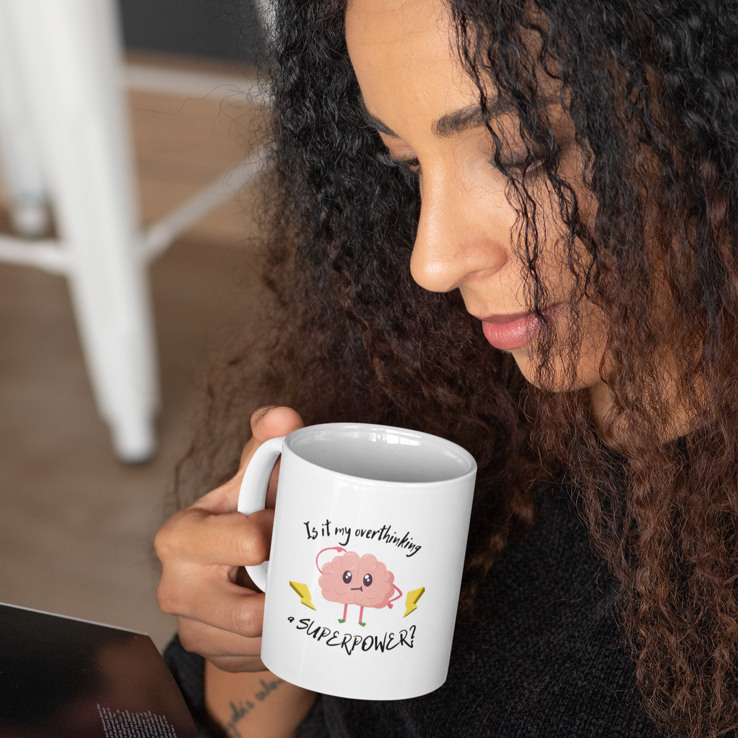 Person holding a white mug with a cartoon pig design and using a tablet.