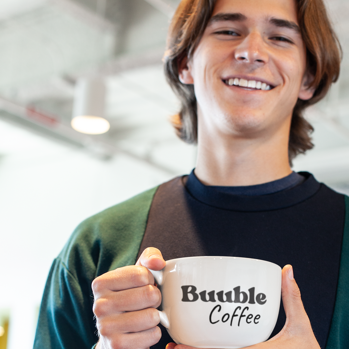 Person holding a white mug with 'Buuble Coffee' text.