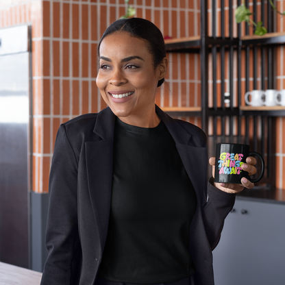 Woman in black outfit holding a mug in a kitchen setting.
