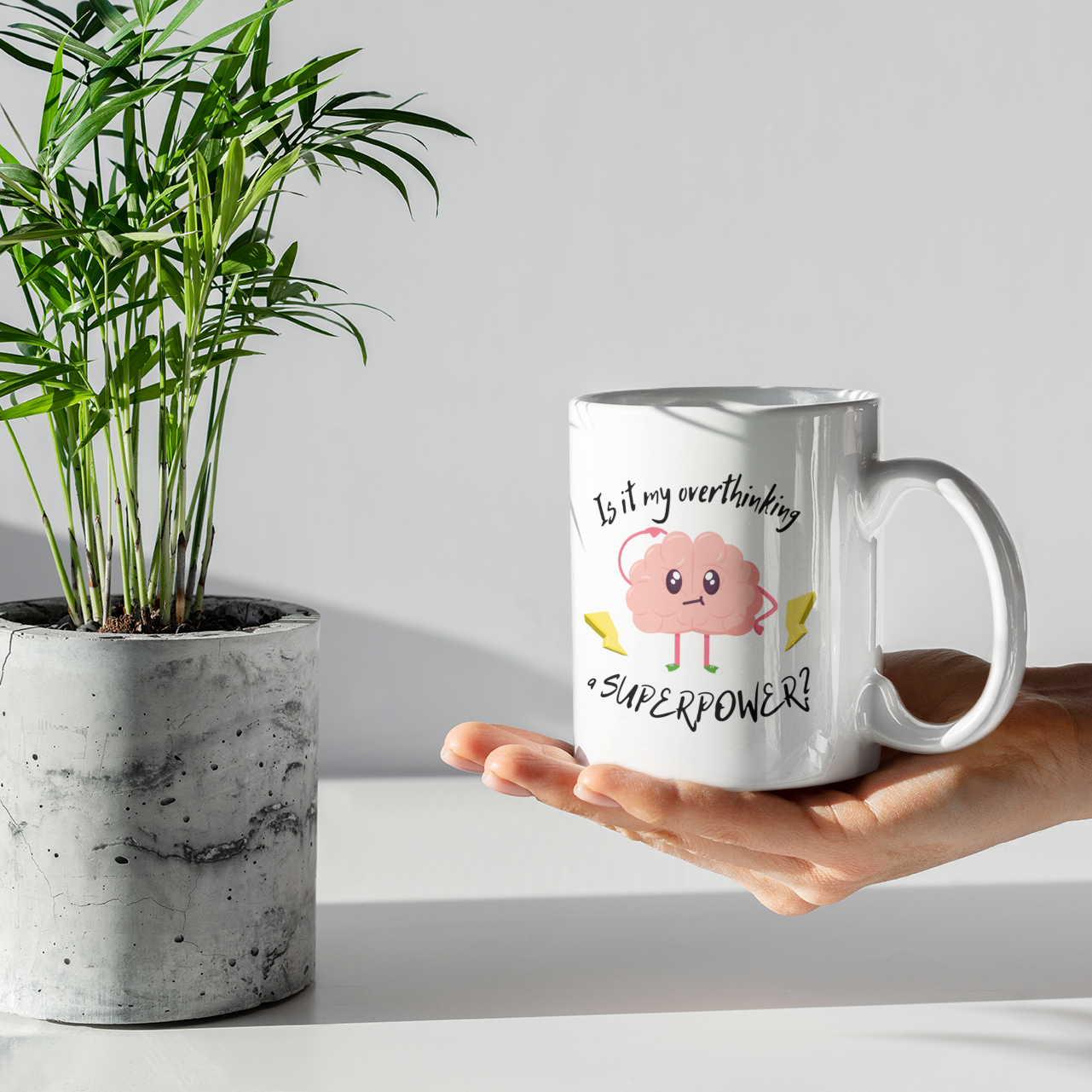 Hand holding a mug with a pig design and text next to a potted plant.