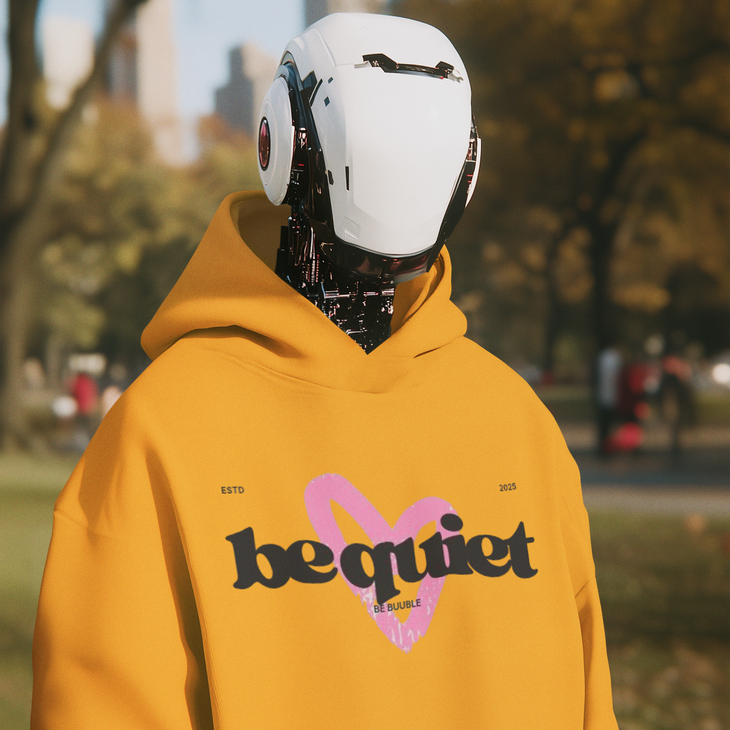 Person wearing a yellow hoodie with 'be quiet' text in an urban park setting