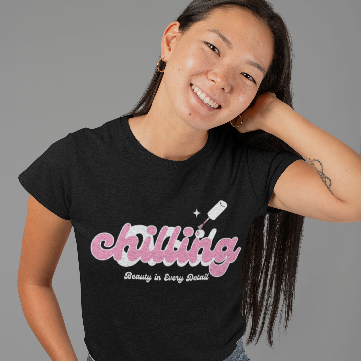 Person wearing a black t-shirt with 'chilling' graphic design on a gray background