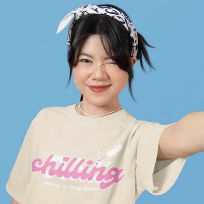 Person wearing a beige t-shirt with 'chilling' text on a blue background