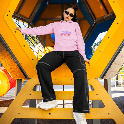Person wearing a pink hoodie and black pants on a playground structure