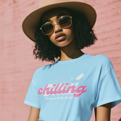 Person wearing a light blue t-shirt with 'chilling' text, beige hat, and sunglasses against a pink brick wall.