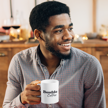 Man holding a mug with 'Buuble Coffee' text in a home setting.