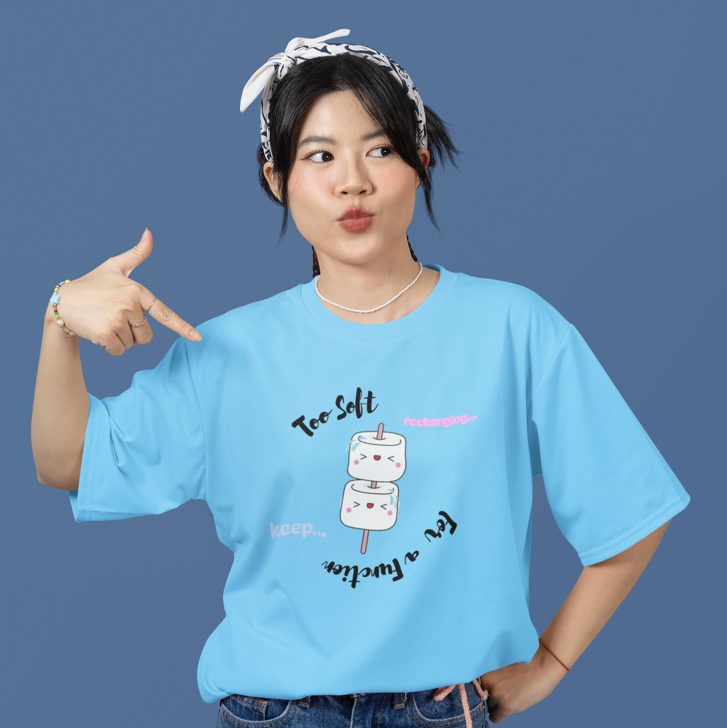 Person wearing a blue t-shirt with a marshmallow graphic and text on a solid background