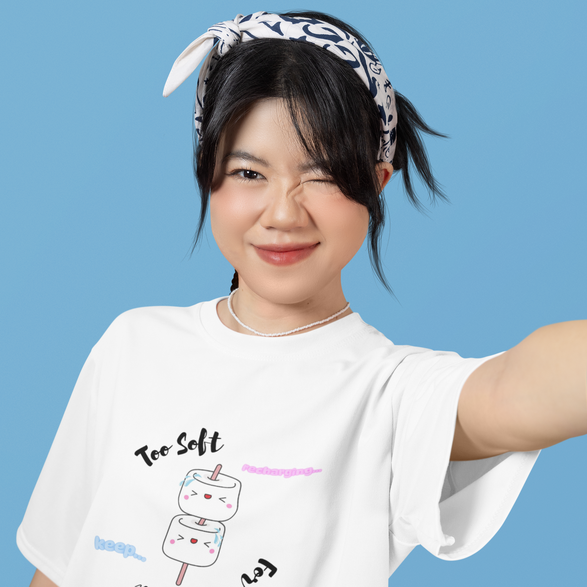Person wearing a white t-shirt with a graphic design on a blue background