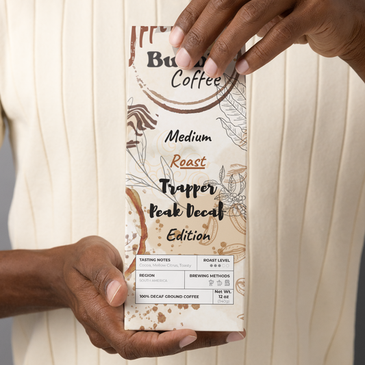 A person holding a bag of Buuble Coffee Trapper Peak Decaf Edition with artistic packaging.