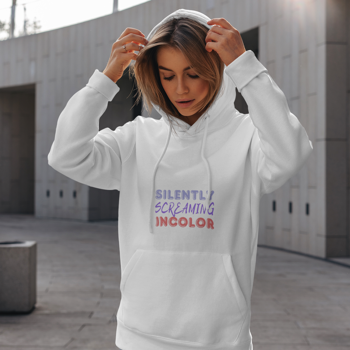 Person wearing a white hoodie with text outdoors